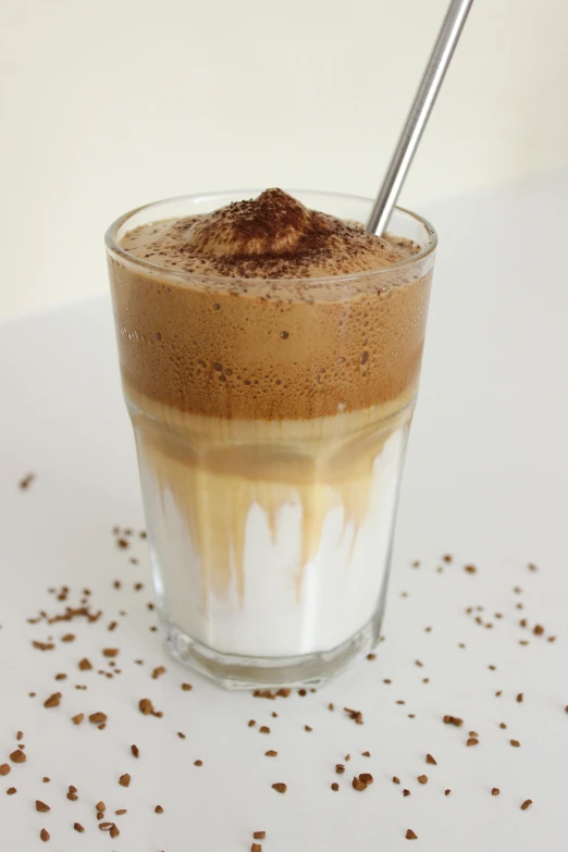 a close up of a cup of coffee on a table, vanilla smoothie explosion, 0, half submerged, sahara
