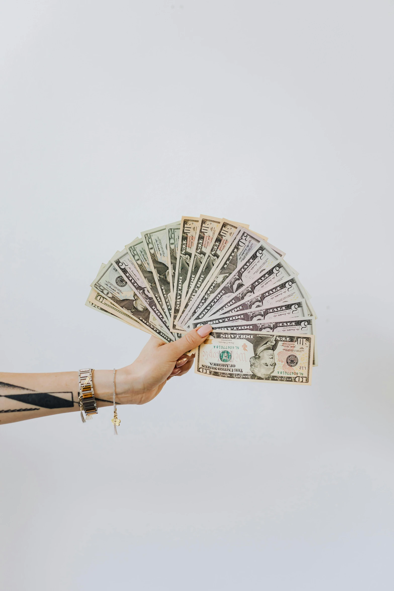 a woman holding a fan of money in her hand, by Kristian Zahrtmann, pexels contest winner, on a white background, 🚀🌈🤩, stacked, kintsugi