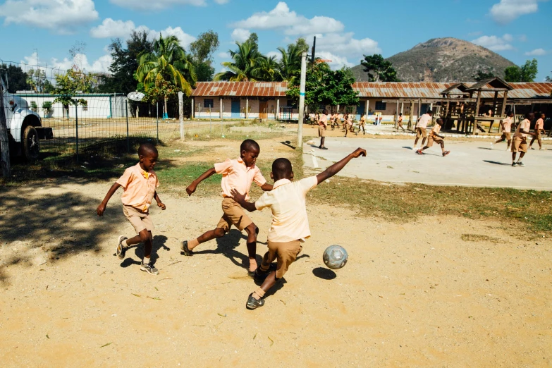 a group of young boys playing a game of soccer, by Carey Morris, pexels contest winner, township, complex background, adrien girod, tourist destination
