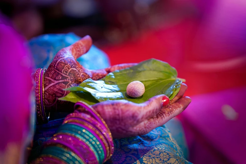 a close up of a person holding a leaf, dressed in a sari, decorations, thumbnail, pink