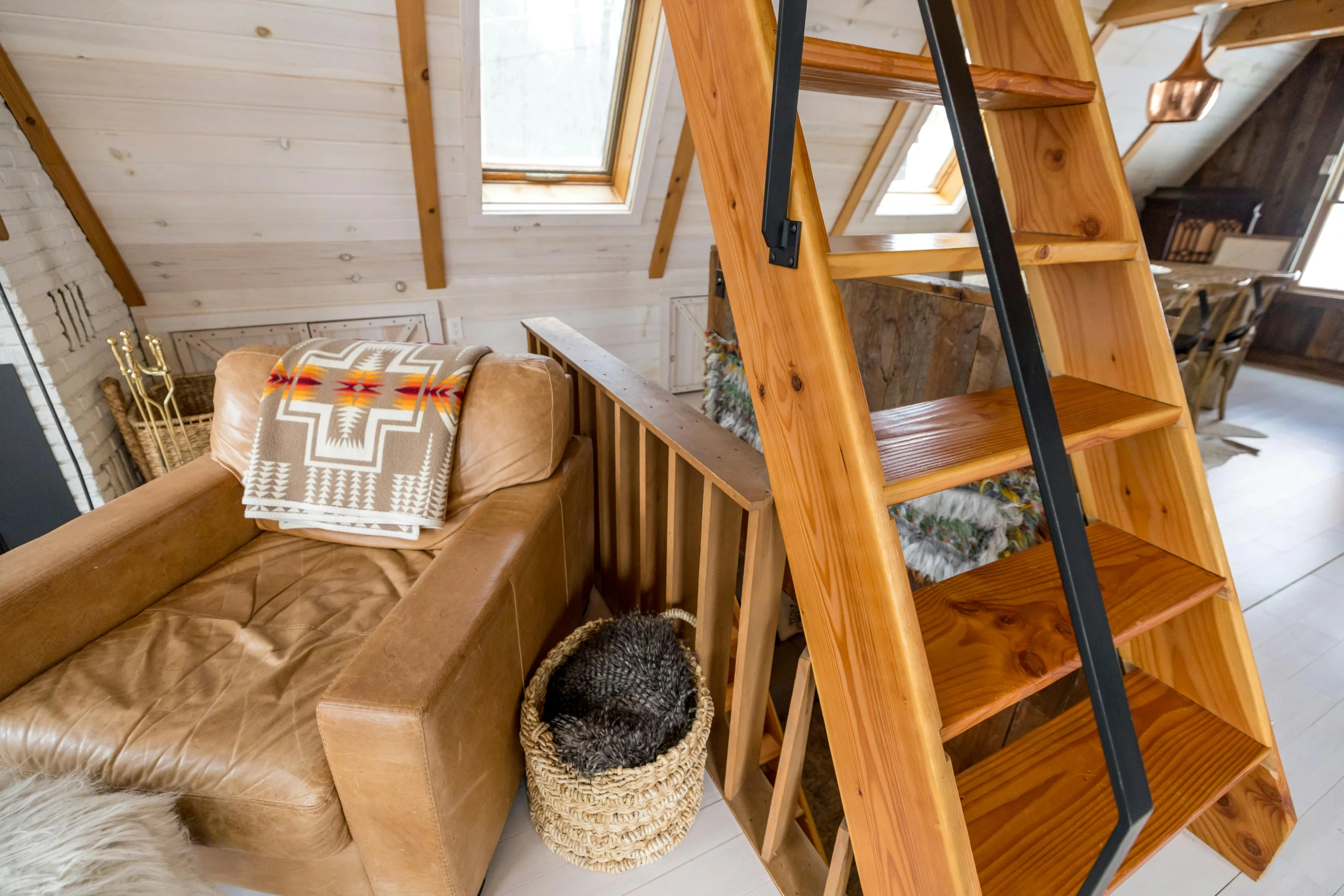 a living room filled with furniture and a wooden ladder, by Julia Pishtar, trending on unsplash, inside of a cabin, top - down view, outdoor staircase, high details photo
