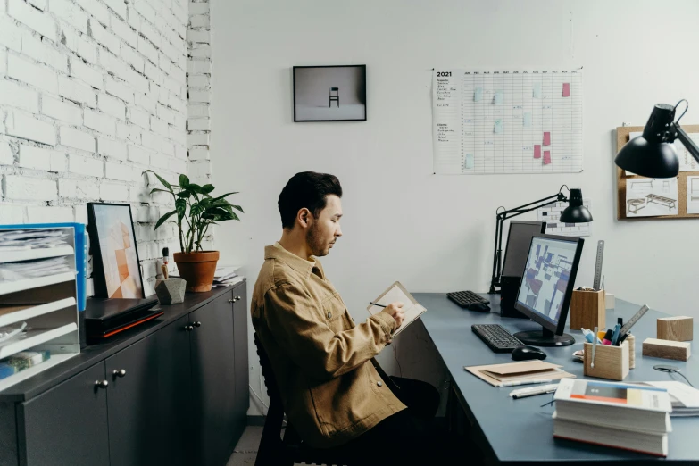 a man sitting at a desk in front of a computer, pexels contest winner, 🦑 design, trying to read, wearing business casual dress, ash thorp khyzyl saleem