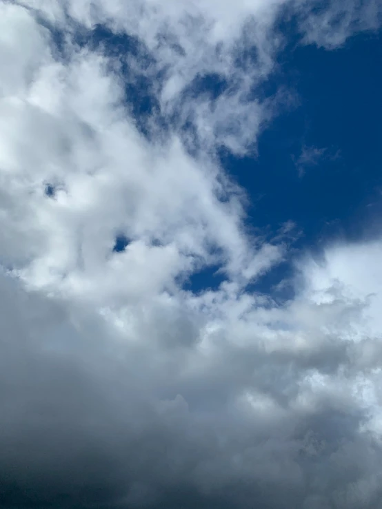 a plane flying through a cloudy blue sky, an album cover, unsplash, hurufiyya, low quality photo, weather report, background image