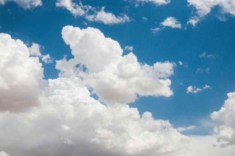 a man flying a kite on top of a lush green field, unsplash, giant cumulonimbus cloud, new mexico, slide show, viewed from a distance