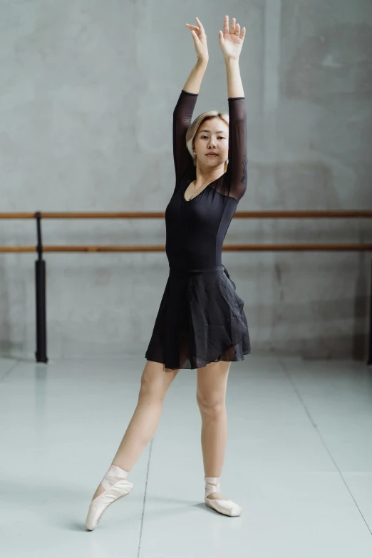 a woman in a black dress standing in a dance studio, a picture, unsplash, 奈良美智, low quality photo, petite, square