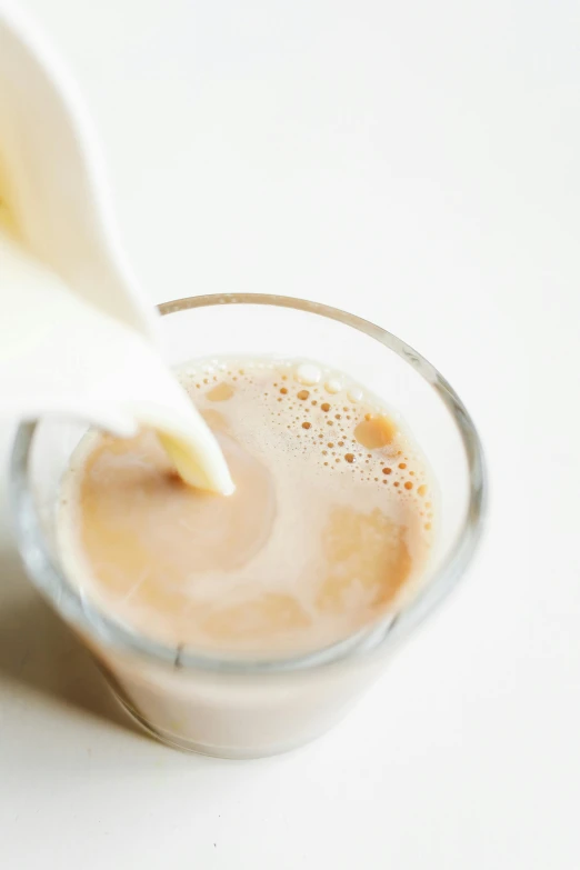 a glass of milk being poured into a cup, tan, square, thumbnail, chiffon