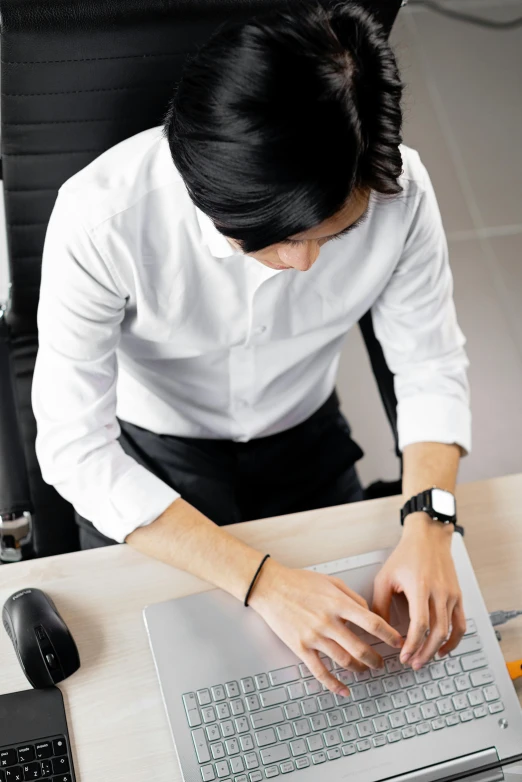 a man sitting at a desk using a laptop computer, inspired by Tadashi Nakayama, trending on unsplash, wearing a white button up shirt, elaborate detail, wearing a black shirt, androgynous person