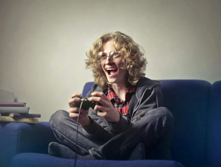 a woman sitting on a couch playing a video game, inspired by Lasar Segall, pexels, hyperrealism, a photo of a disheveled man, laughter, curly blonde hair | d & d, teenage boy