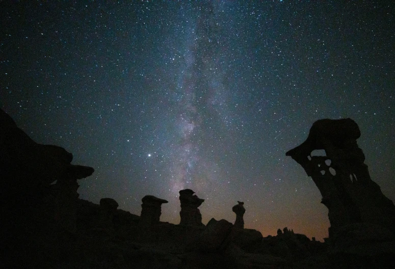 the milky shines brightly in the sky above hoodoooooooooooooooooooooooooooooooooooo, by Chris Rallis, unsplash contest winner, surrealism, ancient alien head stone statues, mushrooms milky way, taken through a telescope, ancient ruins under the desert