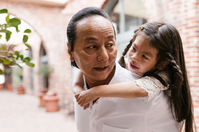 a woman holding a little girl in her arms, inspired by Cui Bai, pexels contest winner, best chef, an oldman, asian male, profile image