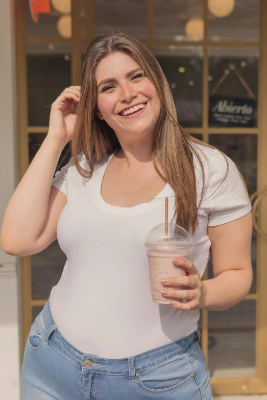 a woman standing in front of a store holding a drink, wearing white v - neck top, milkshake, plus-sized, profile image