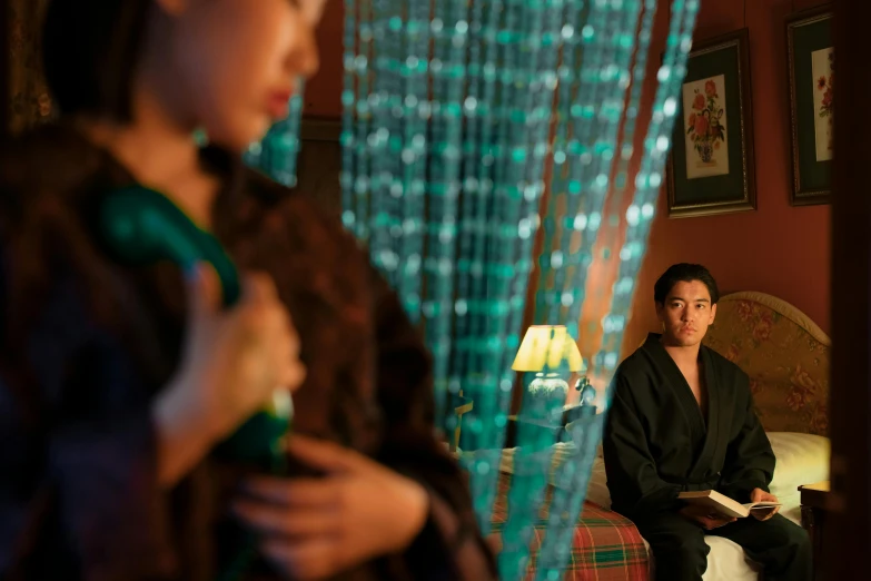 a man and a woman sitting on a bed, inspired by Nan Goldin, unsplash, fantastic realism, traditional chinese clothing, cinestill colour, green robes, lights on