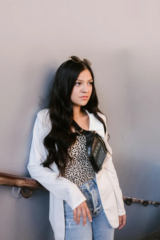 a woman standing in front of a wall, an album cover, inspired by helen huang, trending on pexels, renaissance, wavy long black hair, portrait of white teenage girl, indoor picture, clothing