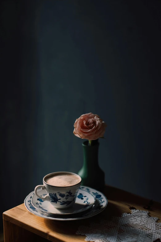 a cup of coffee sitting on top of a wooden table, a still life, by Elsa Bleda, romanticism, blue rose, medium format, khyzyl saleem, ((portrait))