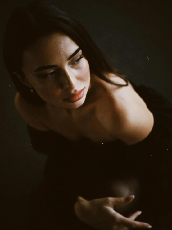 a woman in a black dress posing for a picture, inspired by Elsa Bleda, trending on pexels, renaissance, medium format. soft light, gif, sexy face, grainy photo