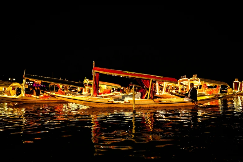 a number of boats on a body of water at night, by Julia Pishtar, pexels contest winner, hurufiyya, artisanal art, side - view, portrait photo, thumbnail