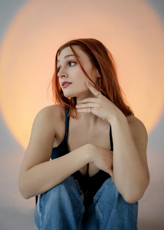 a woman sitting on the ground in front of a sun, an album cover, inspired by Elsa Bleda, featured on reddit, renaissance, red hair and attractive features, portrait sophie mudd, hand on cheek, in a photo studio