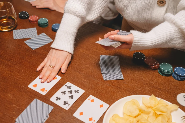 a person sitting at a table with cards and chips, a screenshot, by Adam Marczyński, pexels contest winner, hands reaching for her, flat lay, 🦩🪐🐞👩🏻🦳, pair of keycards on table