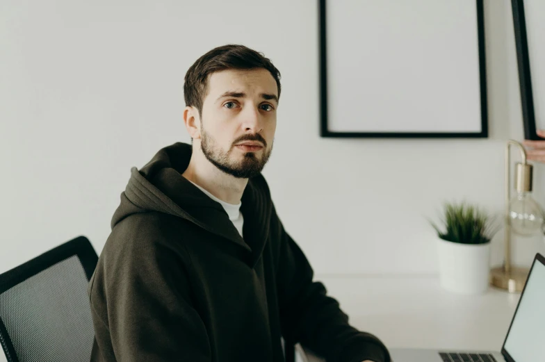 a man sitting in front of a laptop computer, by Adam Marczyński, discord profile picture, looking serious, background image, casually dressed