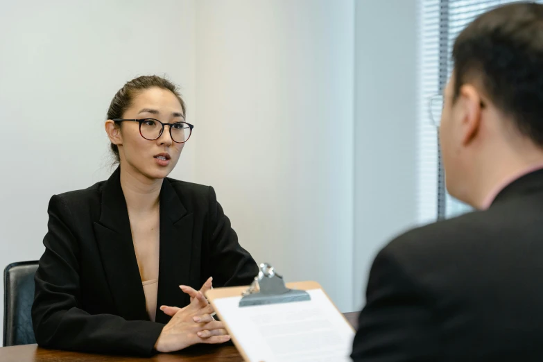 a woman sitting at a table talking to a man, professional photo-n 3, pokimane, asian descent, female lawyer
