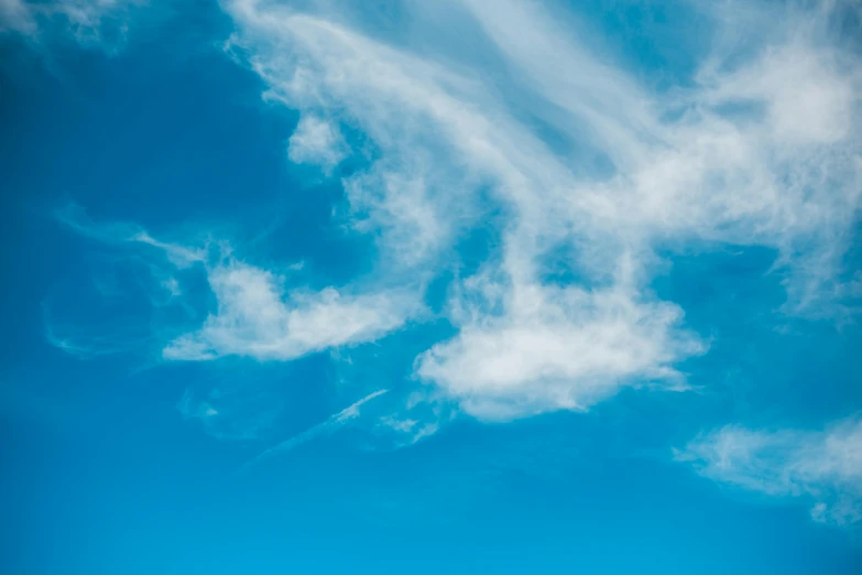 a man riding a snowboard on top of a snow covered slope, by Rachel Reckitt, pexels contest winner, minimalism, cirrus clouds, with a blue background, cloud nebula, ( few clouds )