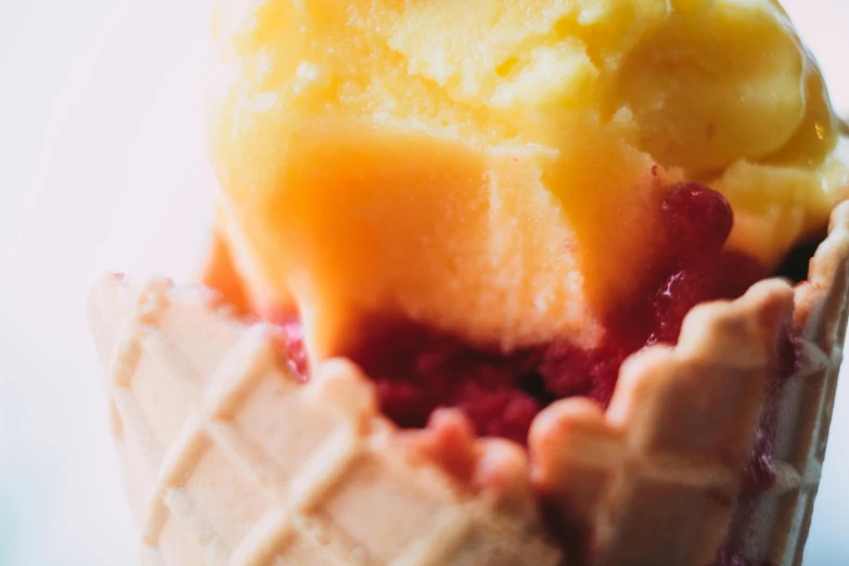 a close up of a cone of ice cream, a macro photograph, unsplash, yellow and red, cupcake, deconstructed waffle, raspberry