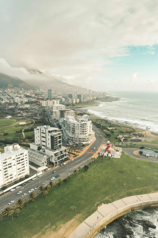 an aerial view of a city next to the ocean, by Daniel Lieske, pexels contest winner, south african coast, grass field surrounding the city, 4 k cinematic panoramic view, helipad