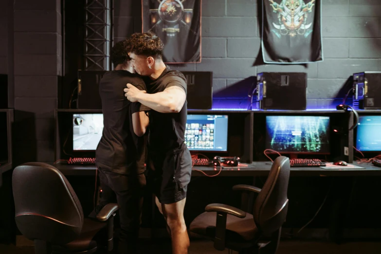 two men hugging each other in front of computer monitors, riot games, profile image, hugging his knees, two muscular men entwined