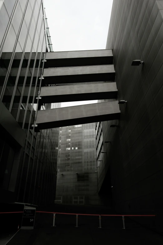 a black and white photo of a very tall building, a black and white photo, unsplash, brutalism, misty alleyways, morphosis, in chippendale sydney, looking downwards