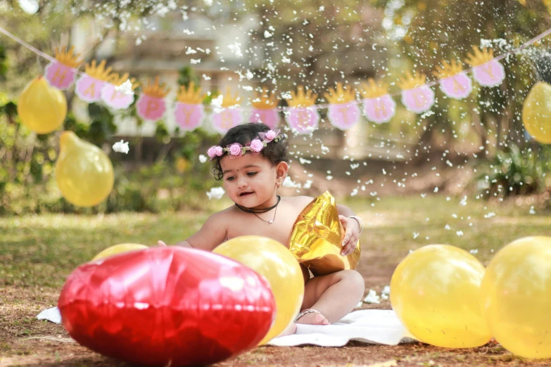 a baby girl sitting in the grass surrounded by balloons, by Bernardino Mei, pexels contest winner, vinayak, pink and yellow, cake, splashing