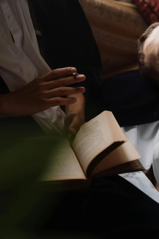 a man laying on a couch reading a book, by Niko Henrichon, trending on unsplash, renaissance, medium shot of two characters, hands reaching for her, religious, high angle close up shot