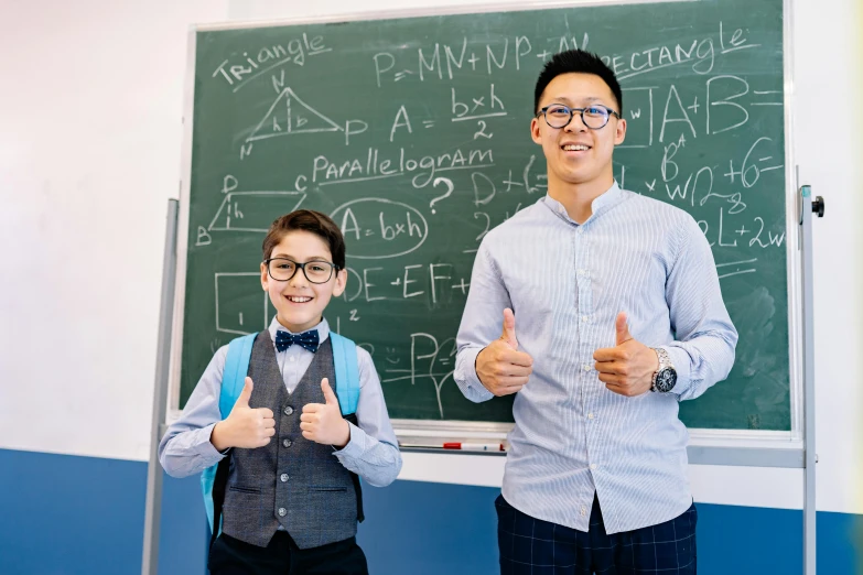 a man standing next to a boy in front of a blackboard, by Jang Seung-eop, pexels contest winner, danube school, giving the thumbs up, lee griggs and jason chan, 15081959 21121991 01012000 4k, wearing medium - sized glasses