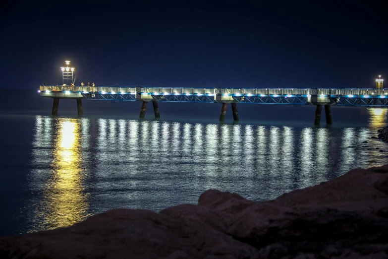 a pier in the middle of a body of water at night, a picture, manly, cyprus, 2022 photograph, fan favorite