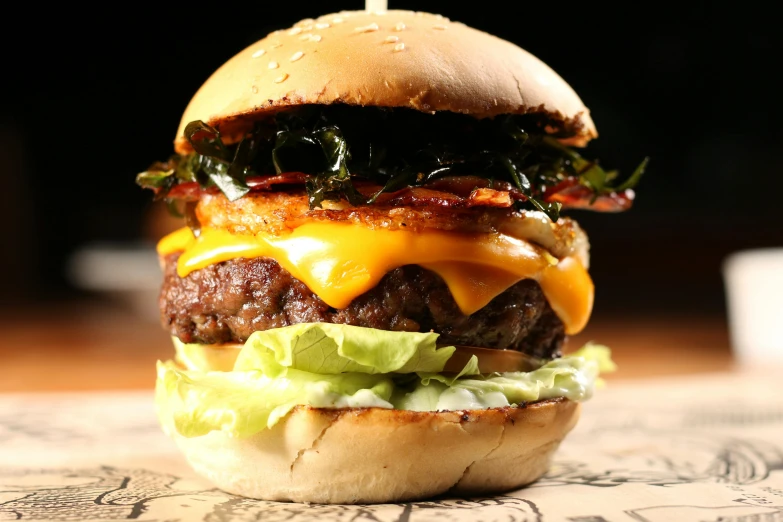 a large cheeseburger sitting on top of a table, a portrait, by Joe Bowler, unsplash, extra bacon lettuce and tomato, melted cheddar, outback, profile image