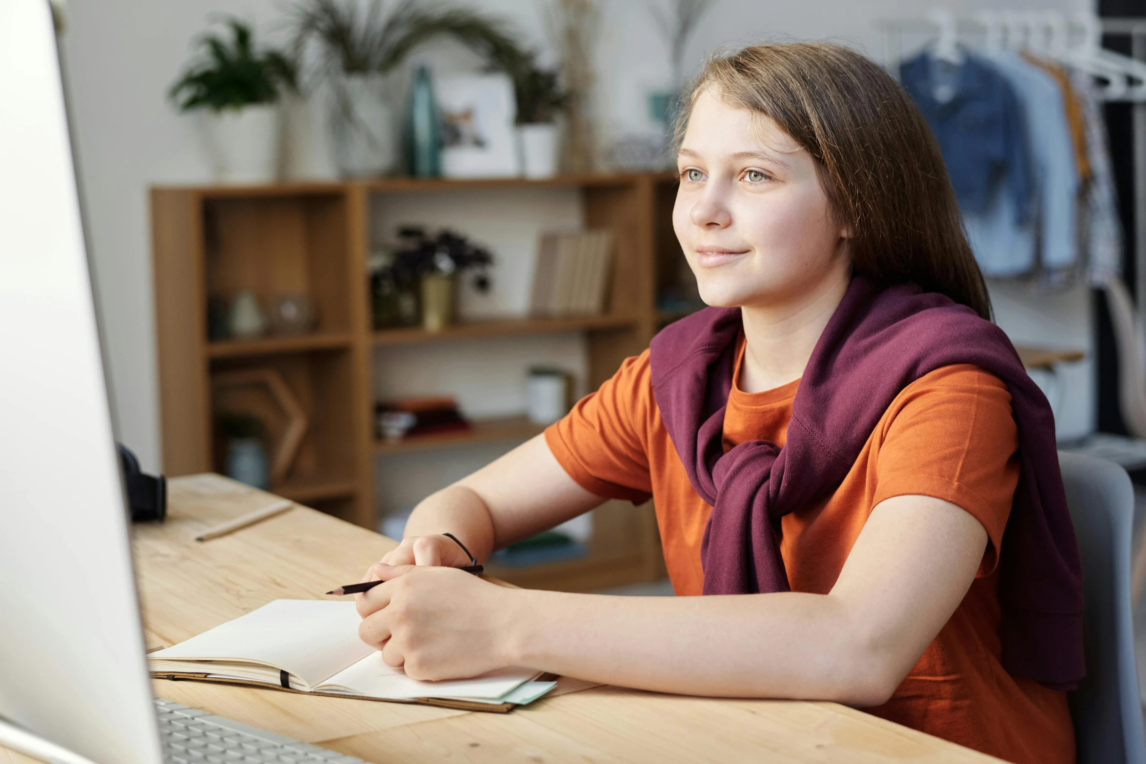 a woman sitting at a desk in front of a computer, for junior, sarenrae, looking across the shoulder, uncropped