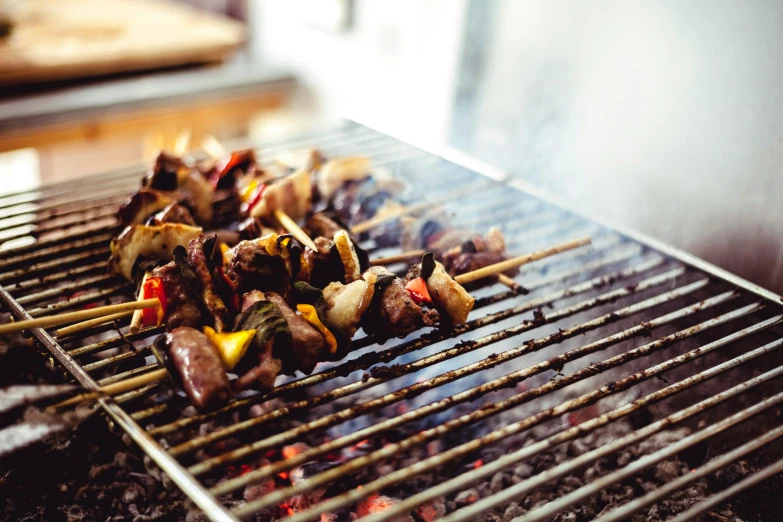 a close up of a grill with skewers on it, by Joe Bowler, unsplash, “ iron bark, epicurious, with street food stalls, avatar image