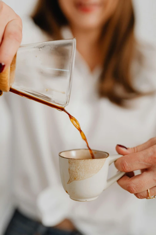 a woman pours coffee into a cup, by Julia Pishtar, pexels contest winner, renaissance, manuka, vanilla, really long, lightly dressed