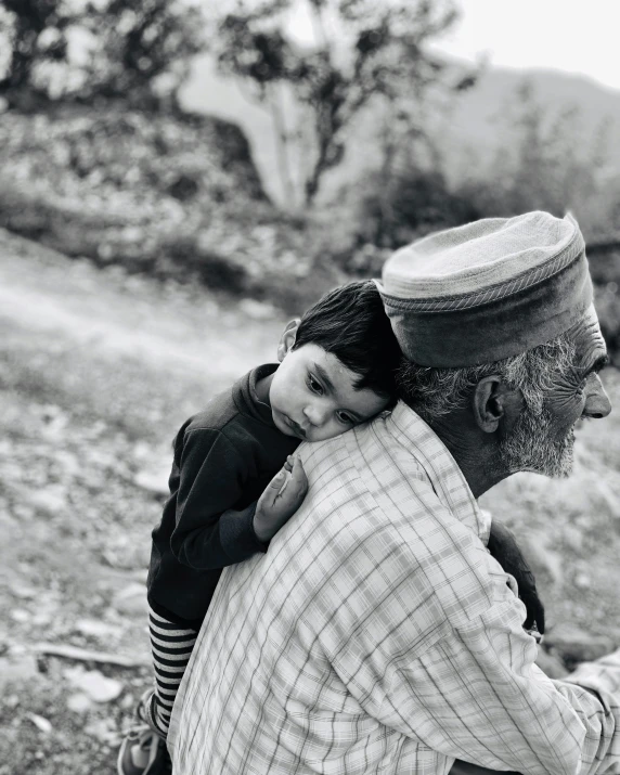 a black and white photo of a man holding a child, by Riza Abbasi, pexels contest winner, hurufiyya, grey beard, in the hillside, lgbtq, instagram story