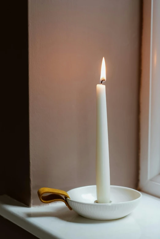 a white candle sitting on top of a window sill, a still life, by Nina Hamnett, soft rim light, spire, ring lit, made of glowing wax and ceramic