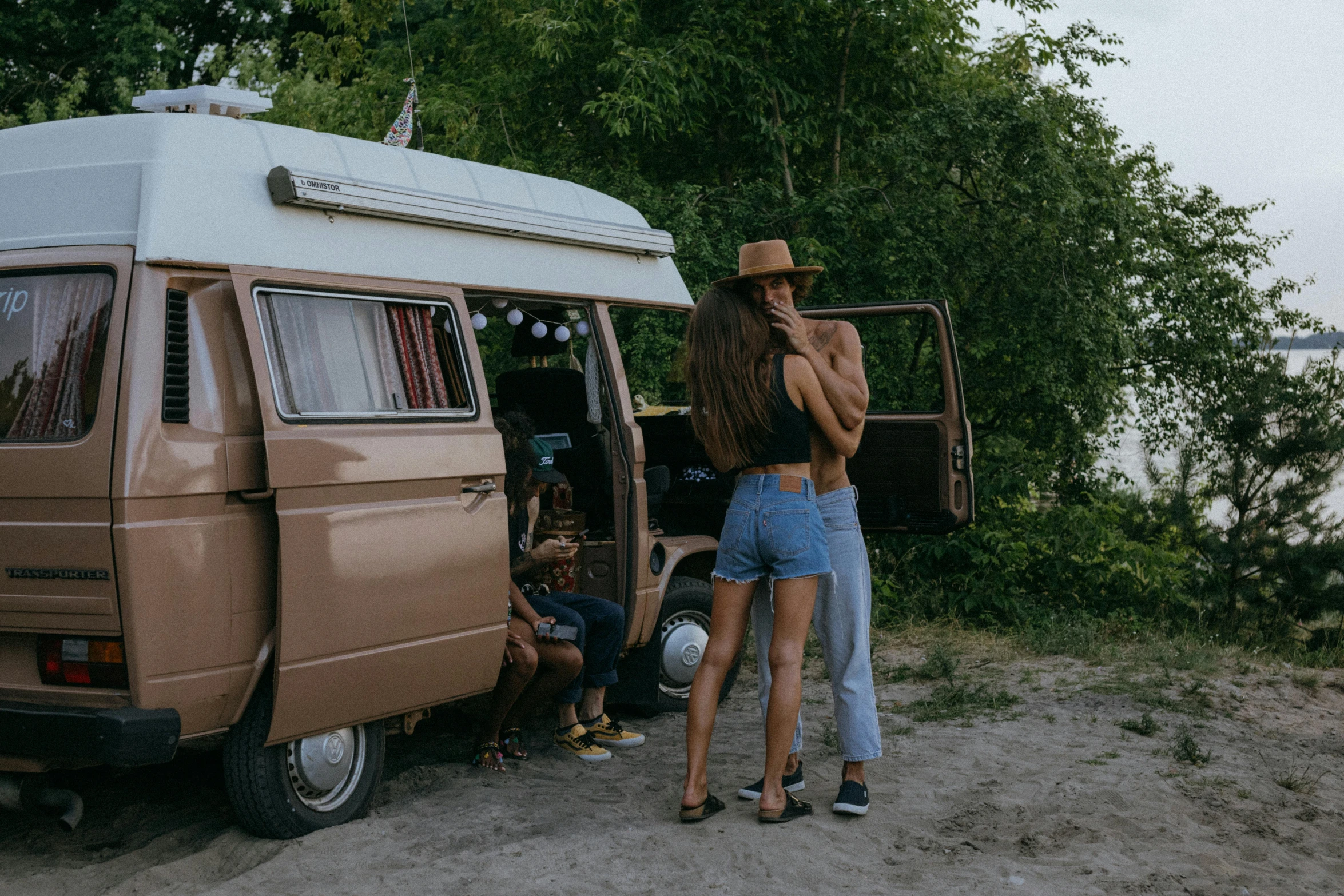 a woman standing next to a van on a dirt road, a polaroid photo, by Justus van Gent, pexels contest winner, renaissance, families playing, tan skin a tee shirt and shorts, lovers, maxim sukharev