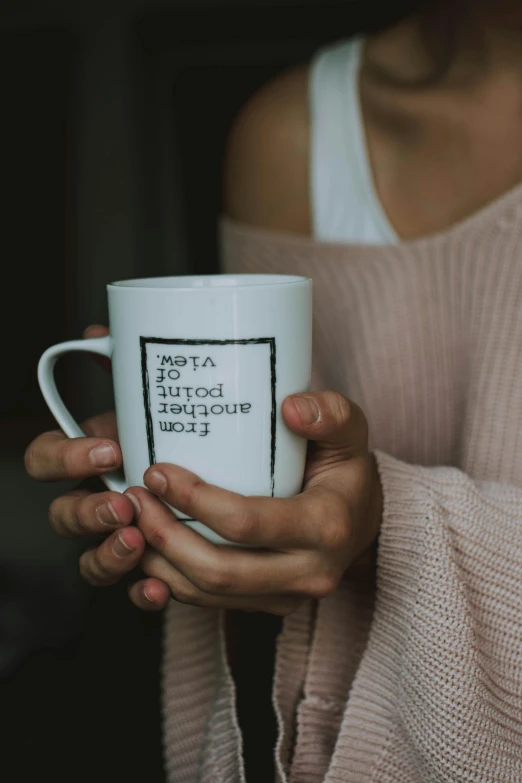 a woman holding a coffee mug in her hands, by Lucia Peka, pexels, subtitles, introverted, white mug, high quality photo