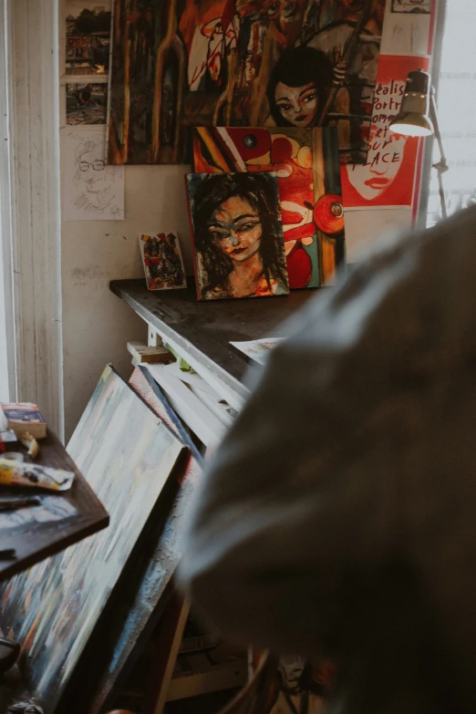 a man sitting at a table in front of a painting, pexels contest winner, inside a cluttered art studio, painting of mona lisa, looking from shoulder, high quality photo