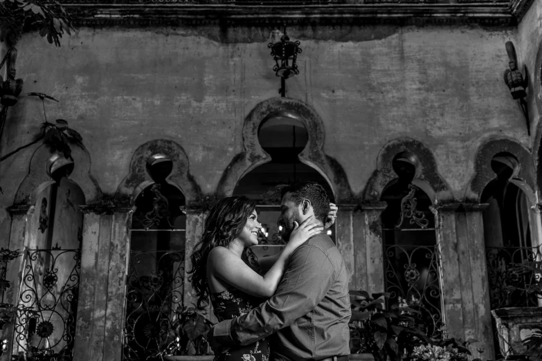 a couple standing next to each other in front of a building, a black and white photo, renaissance, tlaquepaque, with dramatic lighting, love story, very excited