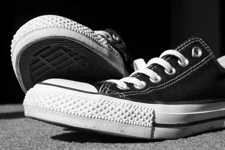 a black and white photo of a pair of sneakers, by Matija Jama, pexels, sots art, highdetailed, converse, black canvas, low details