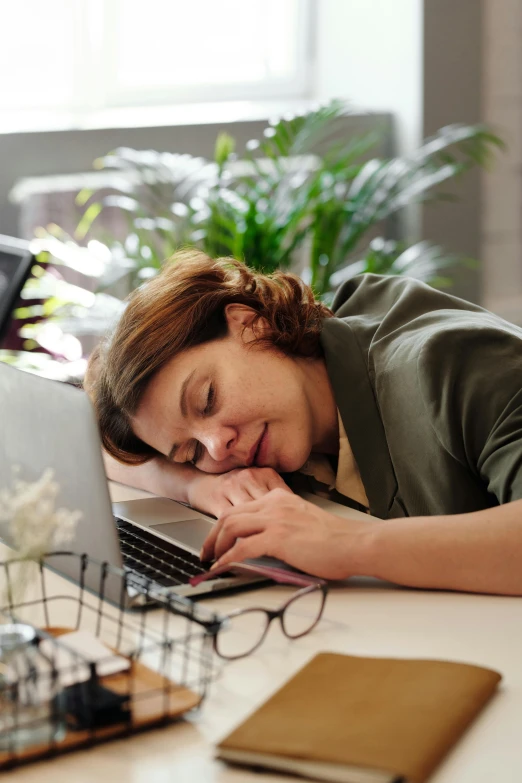 a woman sleeping on a desk next to a laptop, thumbnail, day time, full faced, laying down
