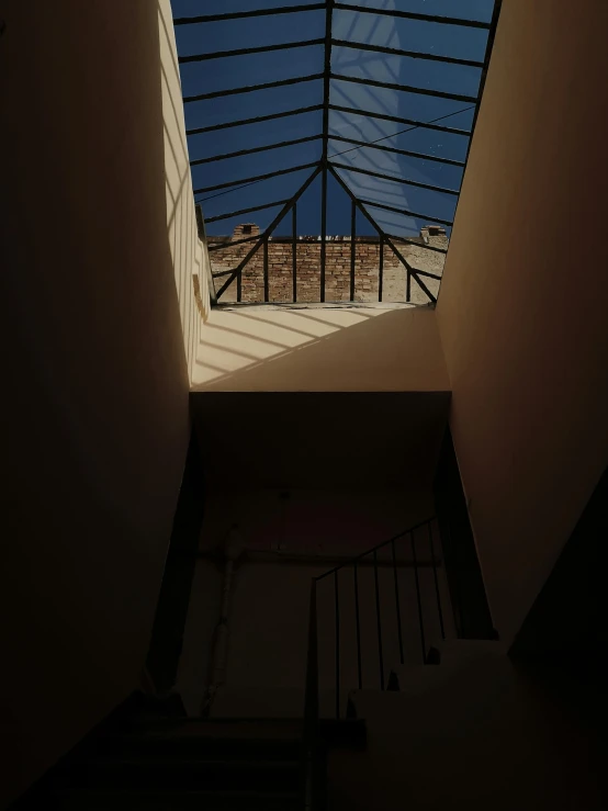 a view of a skylight from inside a building, an album cover, inspired by André Kertész, unsplash contest winner, backlighted, low angle!!!!, evening light, dramatic lighting - n 9