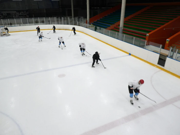 a group of people playing a game of ice hockey, completely empty, reykjavik junior college, 💣 💥💣 💥, no logo