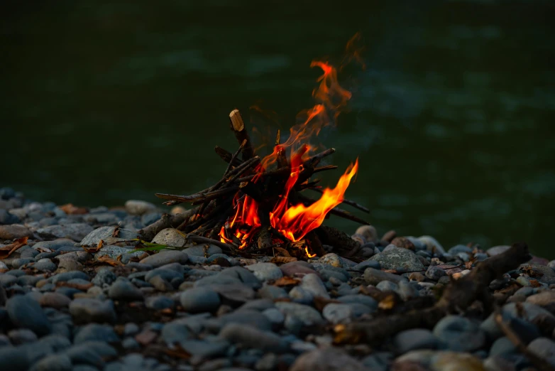 a fire sitting on top of a pile of rocks, pexels contest winner, melting into rivers, campfire, glowing firebugs, ignant