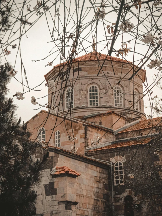 a building with a clock tower surrounded by trees, an album cover, pexels contest winner, romanesque, byzantine, background image, greece, 2 0 2 2 photo