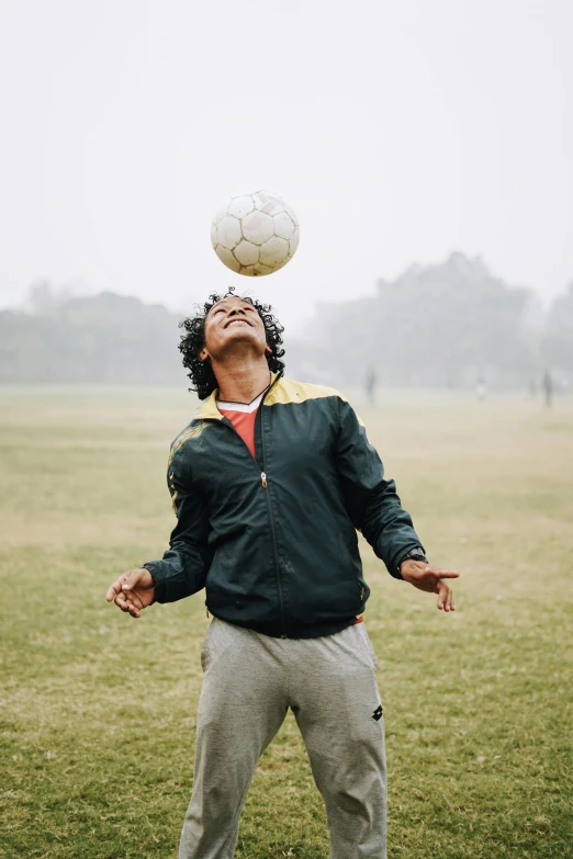 a man balancing a soccer ball on his head, pexels contest winner, a black man with long curly hair, india, on a soccer field, taken in the late 2000s